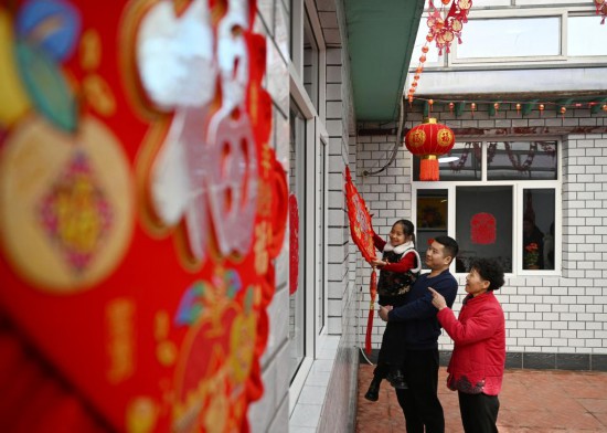2024年2月1日,在天津市西青区辛口镇第六埠村,村民杜洪刚的家人在院子里挂“福”字。新华社记者赵子硕 摄